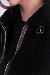 Campera de corderito color beige con ribetes y detalles en símil cuero marrón, cuello alto con hebilla decorativa, bolsillos laterales y cierre frontal.