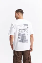Remera blanca de manga corta con cuello redondo y fit regular. Presenta un estampado trasero de estilo postal o etiqueta de envío con dibujos de una cara sonriente, una flor, una palmera y un avión de papel, junto a códigos de barras y la palabra "mistral".