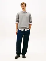 Buzo de cuello redondo Tommy Hilfiger, color gris melange, con diseño clásico y detalles acanalados en cuello, puños y bajo. Cuenta con un pequeño logo gráfico estampado y bordado en el centro del pecho.