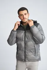 Campera puffer para hombre, color negro con canesú gris, capucha desmontable, cierre frontal con cremallera, bolsillos laterales con cierre y logo de la marca en el pecho.