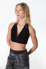 Top corto negro de cuero con escote halter y espalda descubierta.