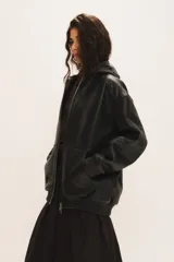 Campera Billie de cuero de oveja negro, con capucha, cierre frontal, bolsillos laterales y puños y cintura elastizados.