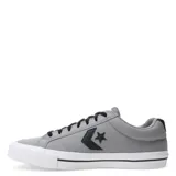 Championes Converse de corte bajo, confeccionados en lona de algodón color gris. Presentan el logo de la marca en el lateral en color negro, cordones negros y suela de goma blanca con una línea decorativa negra.