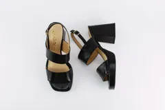 Sandalias de plataforma color crema, con tiras anchas de charol y hebilla ajustable en el tobillo.