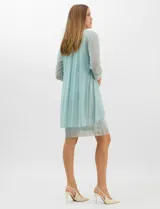 Conjunto de dos piezas compuesto por un vestido corto de silueta recta en tejido plisado metalizado con escote redondo adornado con pedrería y perlas, y una chaqueta de gasa liviana con frente abierto, caída en cascada y mangas tres cuartos con puños metalizados.
