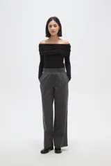 Pantalon de vestir de corte recto y tiro alto, confeccionado en tela de viscosa con diseño de rayas verticales finas en color blanco sobre fondo negro.