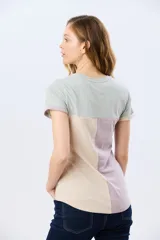 Remera de manga corta con diseño de bloques de color en tonos verde menta, beige y lila, corte clásico y cuello redondo.
