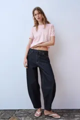 Top de punto de manga corta y cuello redondo, de color rosado con rayas horizontales blancas y aplicación de lentejuelas brillantes en toda la prenda.
