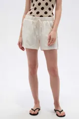 Short de lino color blanco de tiro medio, con bolsillos laterales y cintura elástica con cordón de ajuste.
