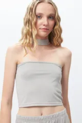 Top strapless gris brillante con cuello choker incorporado, ideal para un look de noche.