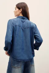 Camisa de denim gris oscuro efecto acid wash, de manga larga, con bolsillos frontales con solapa y broches metálicos a presión.