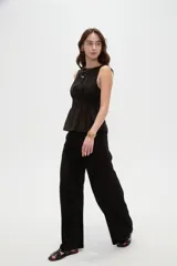 Top de lyocell color negro, sin mangas, con cuello redondo y diseño fruncido con elástico en la cintura que genera un corte peplum.