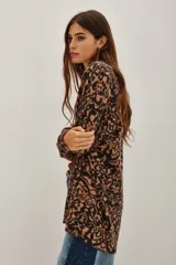 Saco de tejido de punto abierto, sin cuello ni cierre, con estampado tipo ikat o animal print en tonos marrón, negro y rosado pálido.