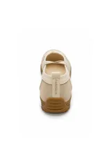 Zapatilla tipo chatita o ballerina color beige, con tiras cruzadas elásticas sobre el empeine, detalles en gamuza y suela de goma marrón con textura.