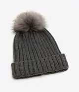 Gorro de punto acanalado en color blanco, con diseño de bajo plegado y pompón superior a tono.
