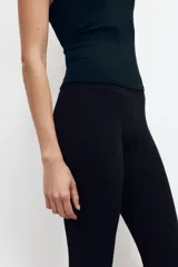 Pantalón de felpa gris melange, tiro alto con cintura elástica ancha y corte flare en las piernas.