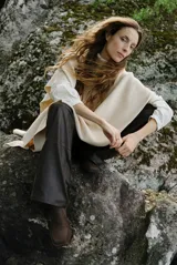 Poncho de tejido de punto color caramelo con cuello alto y diseño holgado sin mangas.