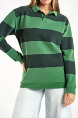 Sweater de punto con diseño de rayas horizontales anchas en tonos verde oscuro y verde claro, con cuello tipo polo y cierre frontal parcial. Presenta mangas largas con puños elásticos y un pequeño bordado en la parte inferior.