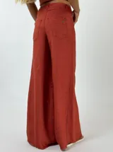 Pantalón de lino color ladrillo, de corte palazzo y tiro alto.