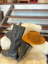 Botas altas de montar de cuero color marrón, con diseño plano y suela de goma.