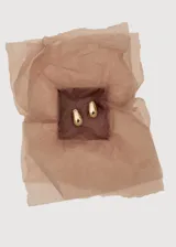 Aros de diseño minimalista con forma de gota o lágrima, con acabado liso y brillante en tono dorado.