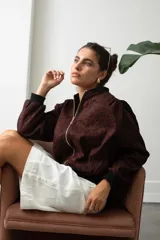 Campera bomber de gamuza con estampado animal print en tono bordó, cierre frontal dorado y puños y cintura de tejido elástico negro.