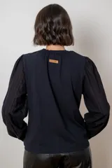 Remera de algodón con cuerpo en color beige y mangas largas abullonadas en color blanco. Presenta cuello redondo con frunces y puños elásticos.