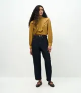 Pantalón de jean corte carrot, color azul oscuro, con cintura alta, cierre frontal con cremallera y botón, y bolsillos laterales.