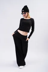 Pantalón tipo palazzo de corte amplio y fluido, color negro, con doble línea lateral blanca y cintura elástica.