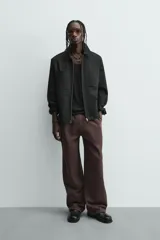 Pantalón jogger de algodón color marrón oscuro, de corte relajado y pierna ancha. Presenta cintura elástica con cordón ajustable y bolsillos laterales y uno trasero de plastrón.