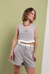Short gris de lino y algodón, tiro alto, con doble pinza delantera, doble pretina y botón de nácar.