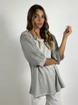 Blusa gris de manga tres cuartos con cuerpo de algodón y mangas abullonadas de tejido liviano y semitransparente. Presenta cuello redondo y un calce holgado.