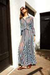 Falda midi de tul con estampado a rayas verticales en tonos marrón y blanco. Tiene volados verticales y cintura elastizada.