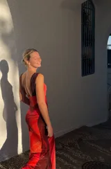 Vestido largo de microtul con estampado abstracto en tonos rojos y naranjas, con escote drapeado y tirantes finos.