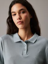 Chomba Calvin Klein slim de punto de algodón suave, color celeste, con cuello polo, tapeta de tres botones, mangas cortas y bordado sutil del logo en el pecho.