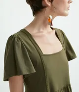 Vestido midi verde militar de algodón, con escote cuadrado, mangas cortas amplias y falda con volantes escalonados.