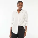 Camisa de popelina blanca de corte clásico, con cuello camisero, cierre frontal de botones y mangas largas con puños abotonados.