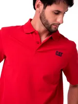 Remera tipo polo de Caterpillar, color rojo, con cuello y puños acanalados. Presenta el logo de la marca bordado en el pecho y un pequeño detalle triangular en la manga.