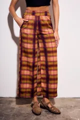 Pantalón de tiro medio y calce recto, confeccionado en poliéster con estampado de cuadros escoceses en tonos burdeos, mostaza, verde oliva y rosado.