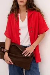 Sobrecamisa roja de lino de manga corta, con cuello solapa, costuras decorativas en contraste y cierre frontal con presillas y botones alargados.
