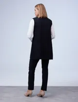 Chaleco largo tejido color blanco de la marca Sioni, con cuello solapa, doble botonadura dorada en el frente y bolsillos aplicados.