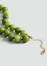 Collar de cuentas esféricas de piedra en tono verde, con cierre de mosquetón y cadena de alargue metálica en color dorado.