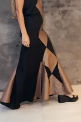 Vestido largo de corte sirena con diseño de rombos en colores violeta y rojo. Presenta breteles finos, escote recto y una falda con caída fluida y cola corta.