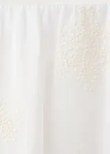 Falda midi evasé de color blanco, confeccionada en algodón con detalles bordados tonales, cintura elástica y forro interior.