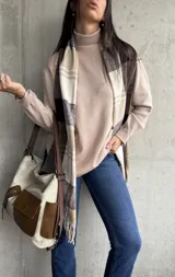 Polera beige de cuello alto y manga larga.