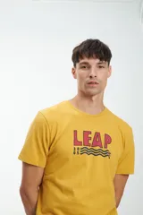Remera amarilla de manga corta con estampa frontal con la palabra "LEAP" en rojo y tres líneas onduladas en azul.