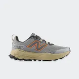 Championes de trekking New Balance Garoé V2, color gris con detalles en naranja y suela beige. Incorporan tecnología Fresh Foam X en la entresuela y suela AT Tread para mayor tracción en senderos.