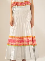 Pollera larga plisada color blanco, con cintura elastizada y estampado multicolor en los bordes del ruedo.