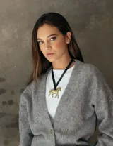 Collar con aplique de caballo de bronce y tira de cuero negro.