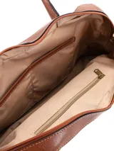 Cartera tipo bowling de cuero gamuza color tostado, con doble asa de mano en cuero liso, cierre superior y logo metálico de la marca en el frente.